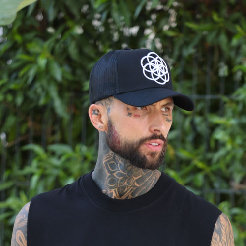 ScarTissue Clothing Core Noir Trucka Hat worn by a heavily tattooed man