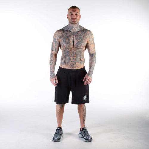 Core Noirse black luxury shorts worn by a heavily tattooed man